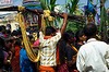 Mężczyzna przechodzi w tłumie z zakupionymi łodygami trzciny cukrowej