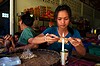 Tajlandia, okolice Tha Song Yang, dziewczyna pakuje orzeszki do foliowych torebek