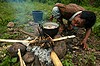 Laos, Don Mai, mężczyzna przygotowuje obiad z upolowanej rano małpy